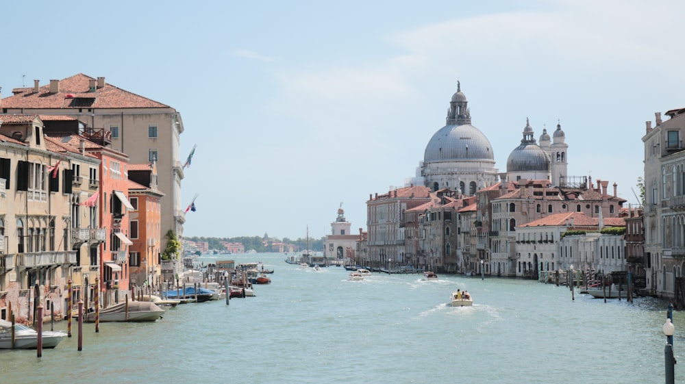 a boat traveling down a river next to tall buildings