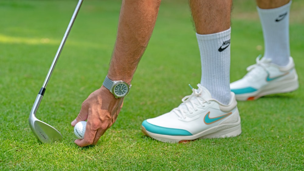 a man putting a golf ball on a tee