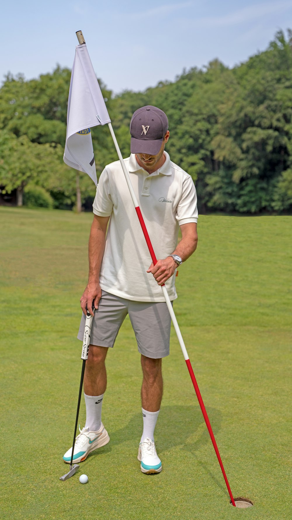 a man holding a golf club and a flag