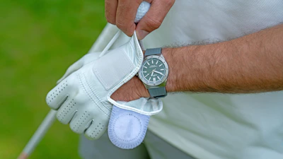 Close-up of stylish golf gloves and sun protection sleeves laid out on a wooden table