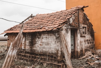 a run down building with a red tiled roof