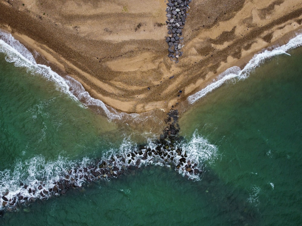 an aerial view of a beach with waves crashing on it