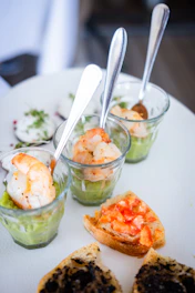a white plate topped with small cups filled with food