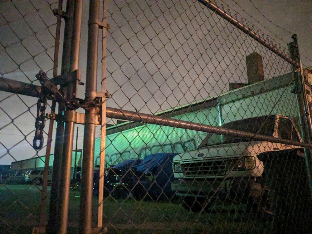 a truck behind a chain link fence at night