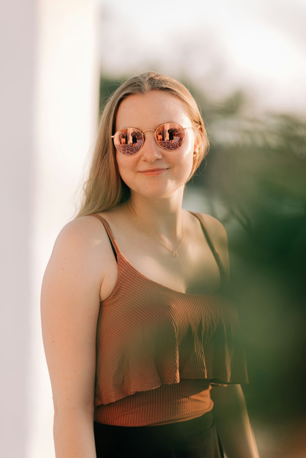 a woman wearing a brown top and sunglasses