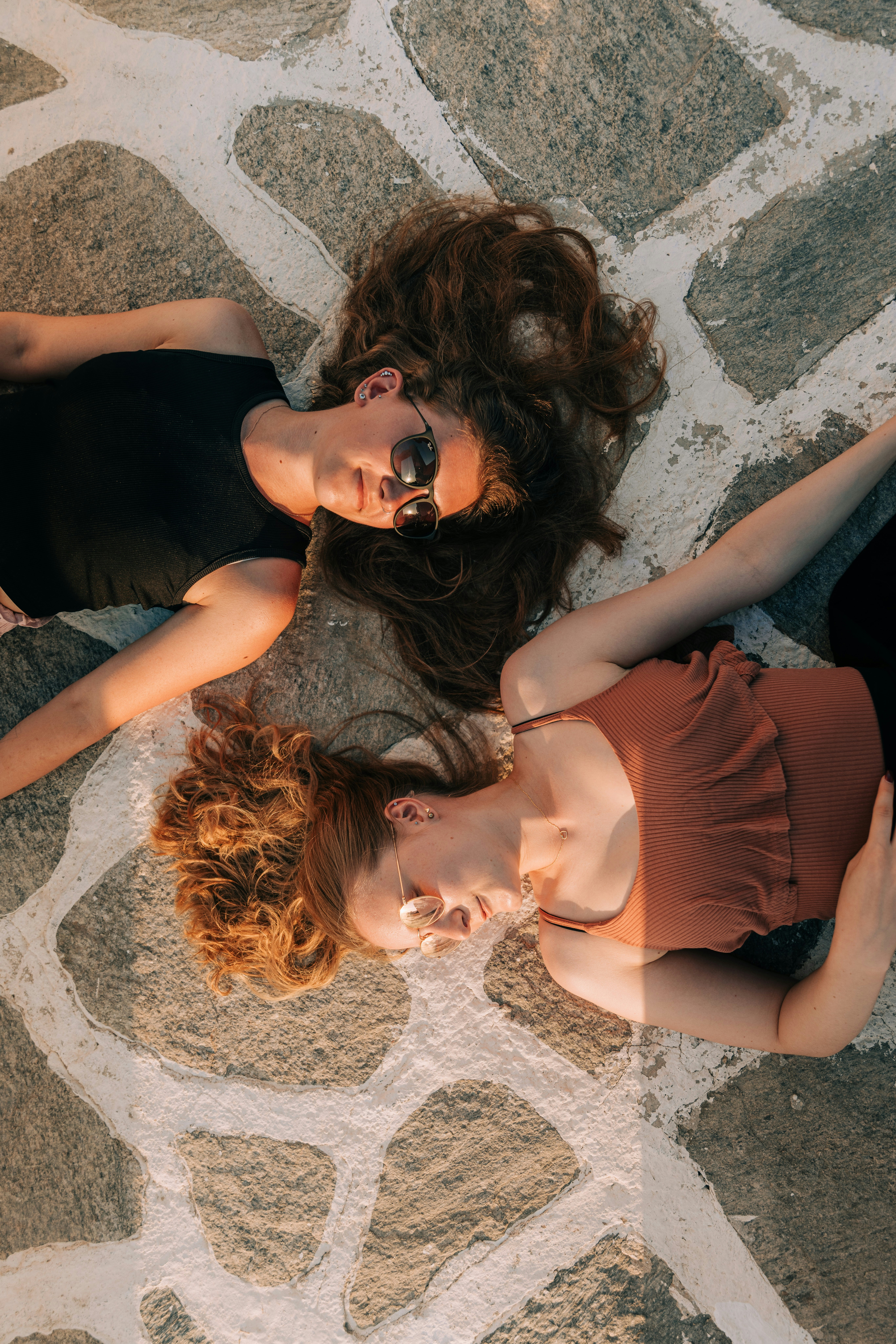 two young women laying on the ground next to each other