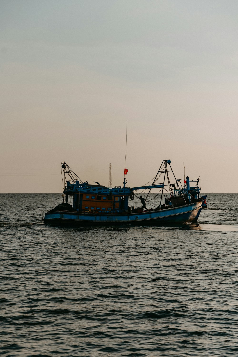 a blue boat in the middle of a body of water