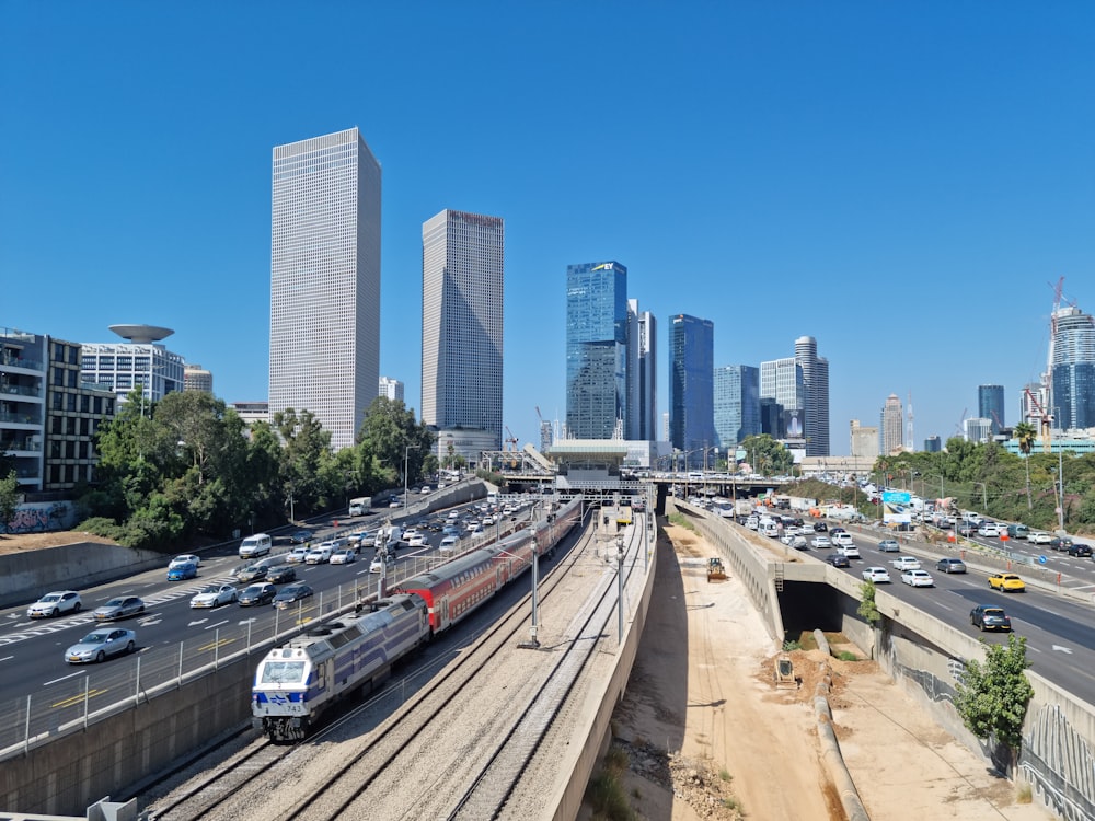 a train traveling through a city next to tall buildings