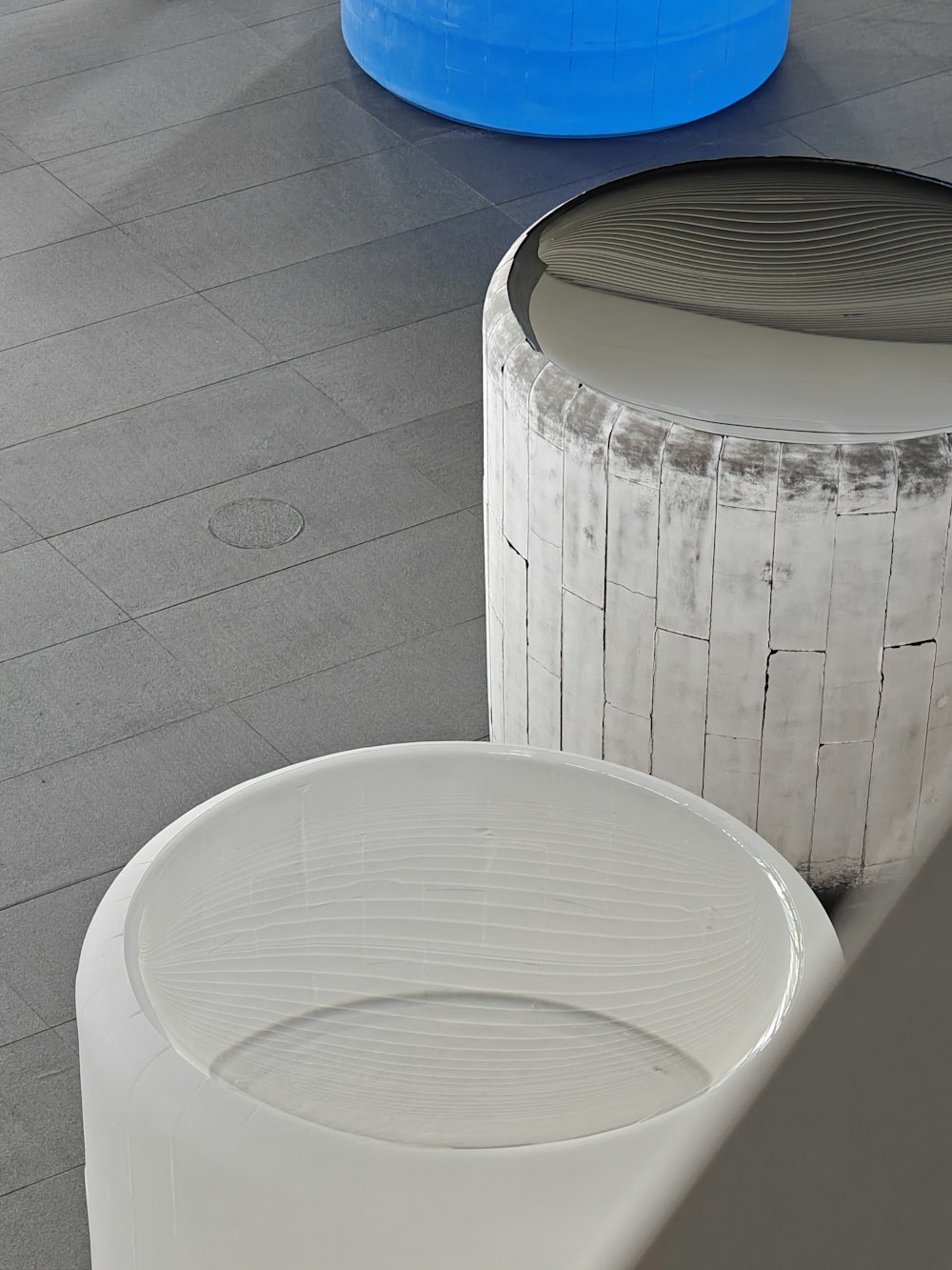 a couple of white stools sitting on top of a cement floor