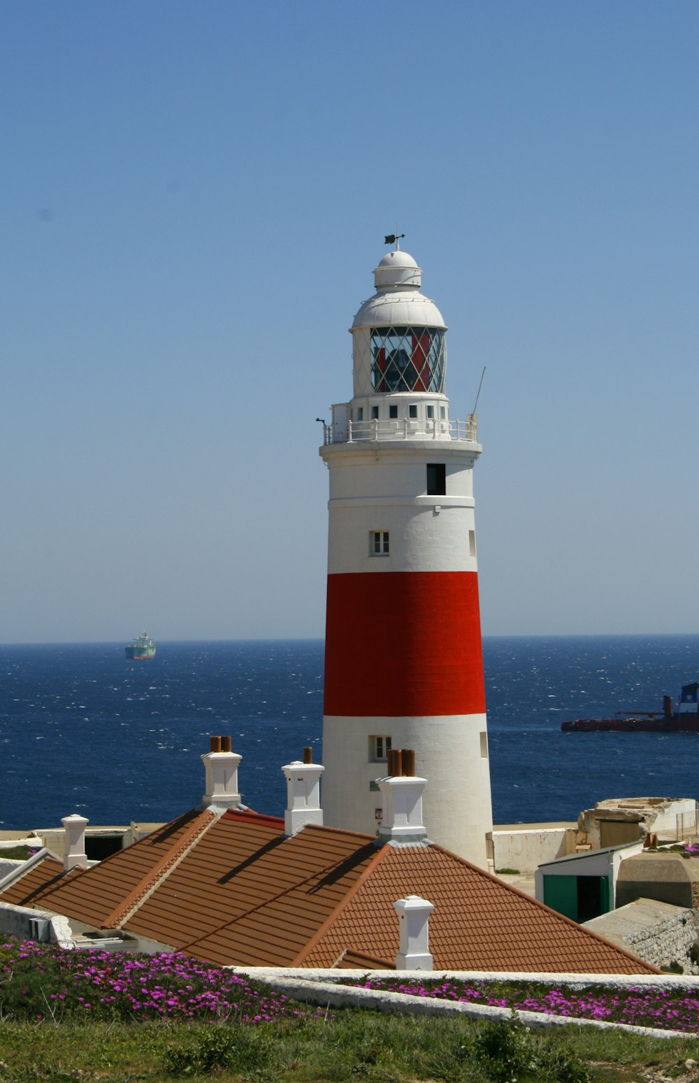 a red and white lighthouse sitting on top of a hill