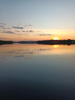 A serene sunrise over a calm lake reflecting vibrant colors.
