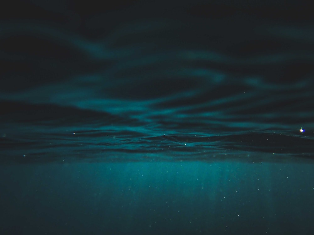 Das Wasser ist sehr dunkel und das Licht scheint auf die Oberfläche