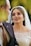 A radiant bride in a stunning wedding gown, showcasing flawless makeup and a joyful smile.
