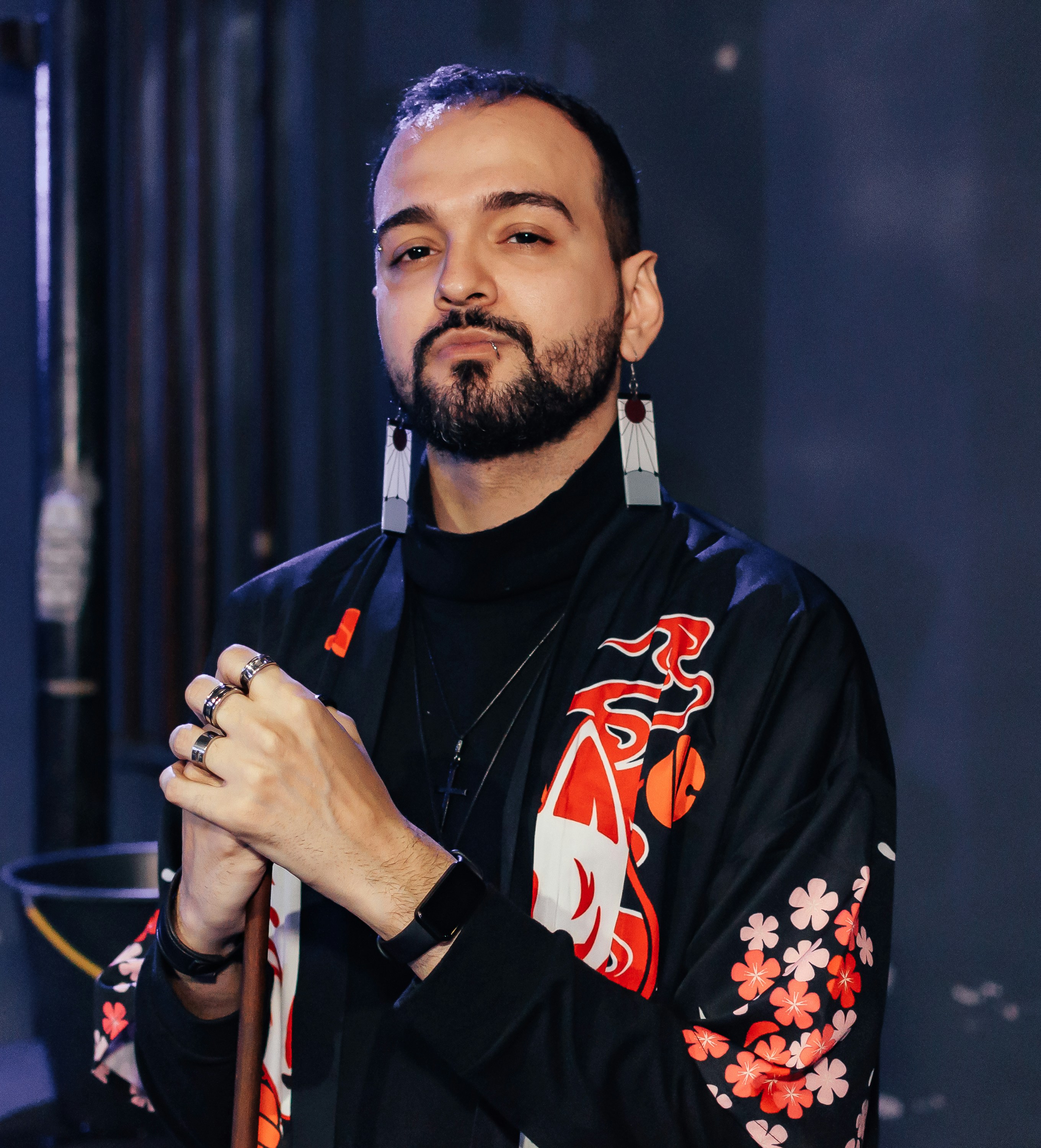 a man in a black shirt and a pair of earrings