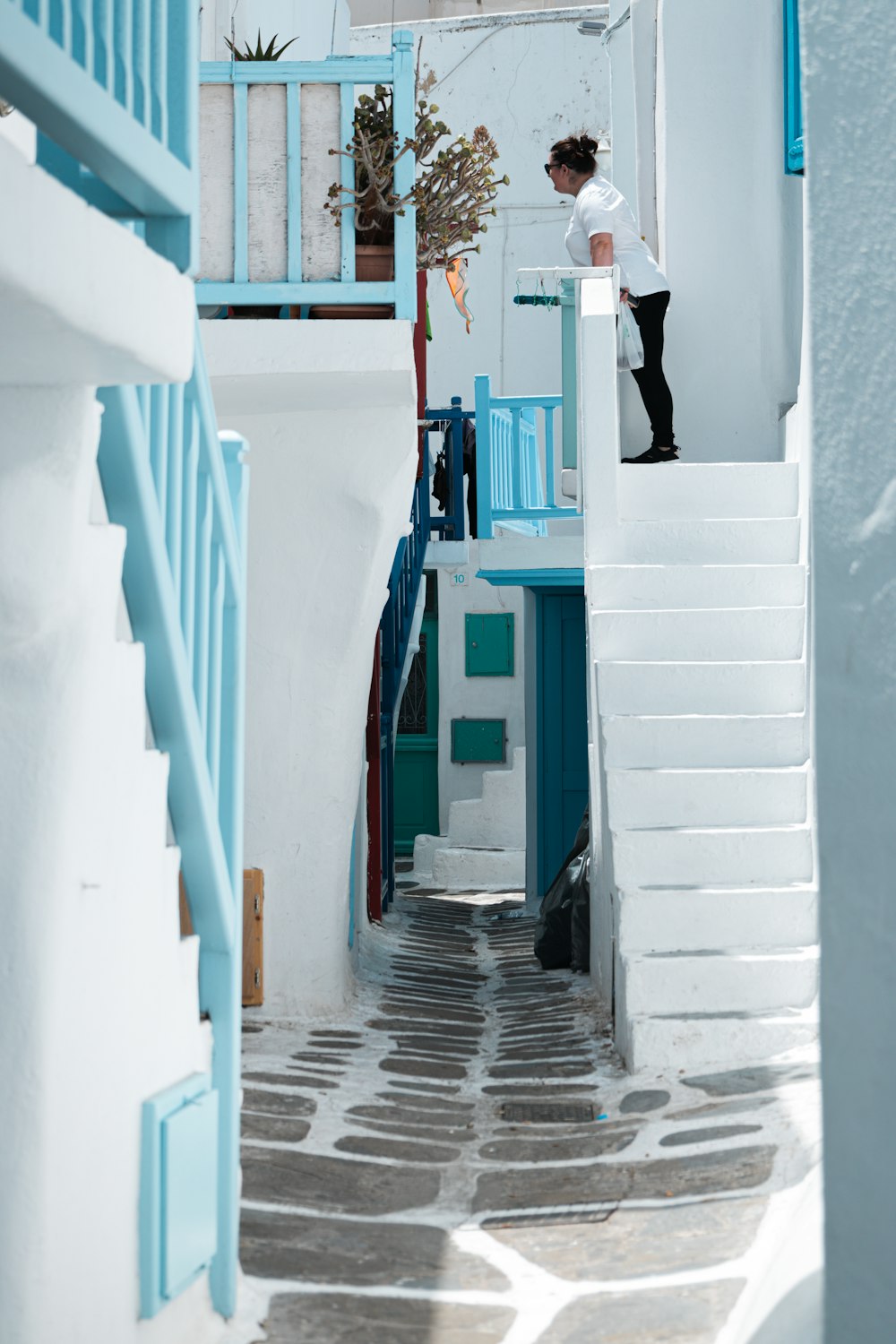 a person standing on a staircase in a narrow alleyway