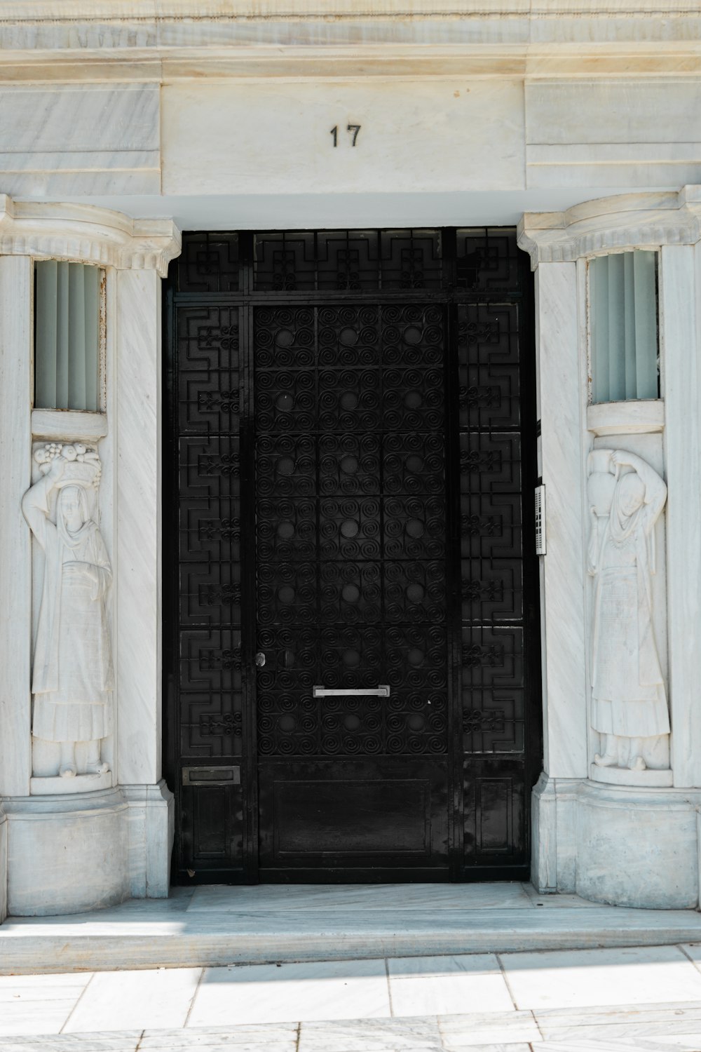a black door with statues on either side of it