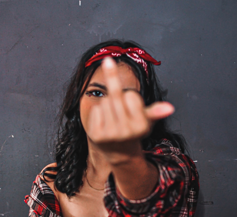 a woman making a hand gesture with her right hand