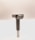 A metal tool with a cylindrical handle and a sharp, angular cutting head is positioned vertically against a plain, light background. The tool appears to be designed for precision cutting or boring tasks.