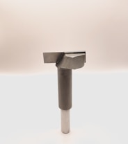 A metal tool with a cylindrical handle and a sharp, angular cutting head is positioned vertically against a plain, light background. The tool appears to be designed for precision cutting or boring tasks.