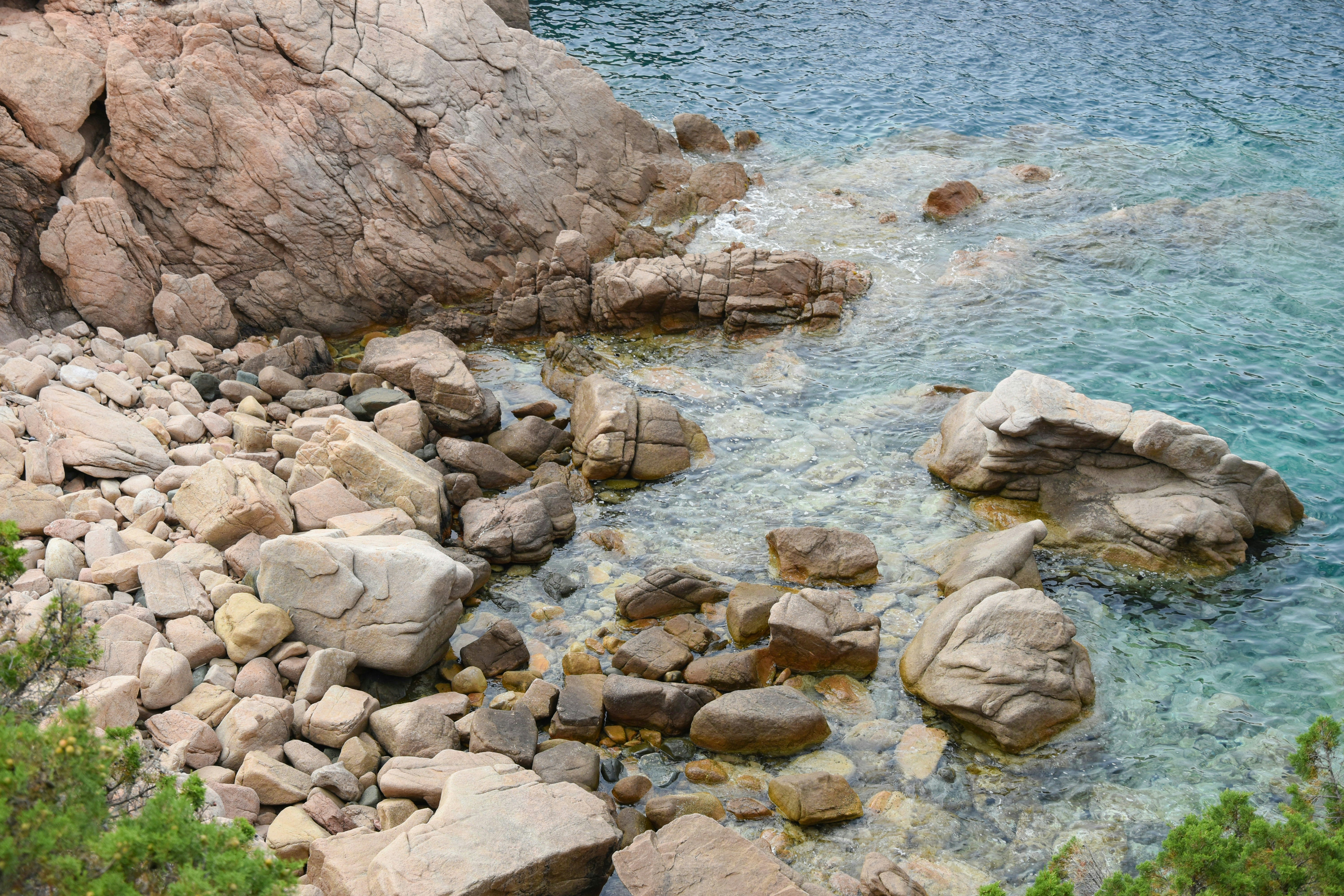 um corpo de água cercado por rochas e grama