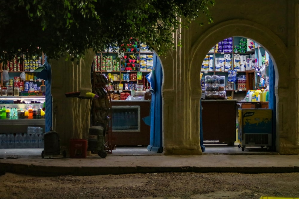 a man standing in front of a store filled with bottles