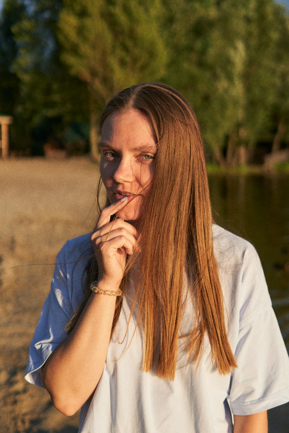 a woman with long hair standing on a beach