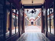 a hallway with a chandelier and a tiled floor