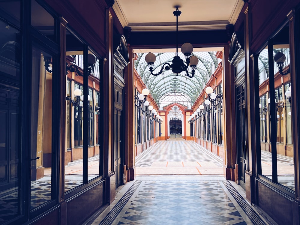 a hallway with a chandelier and a tiled floor