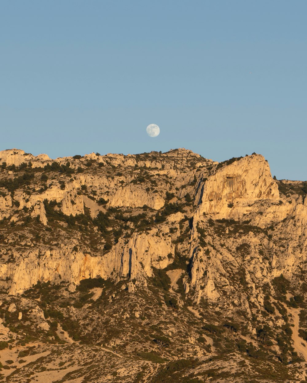 a mountain with a full moon in the sky