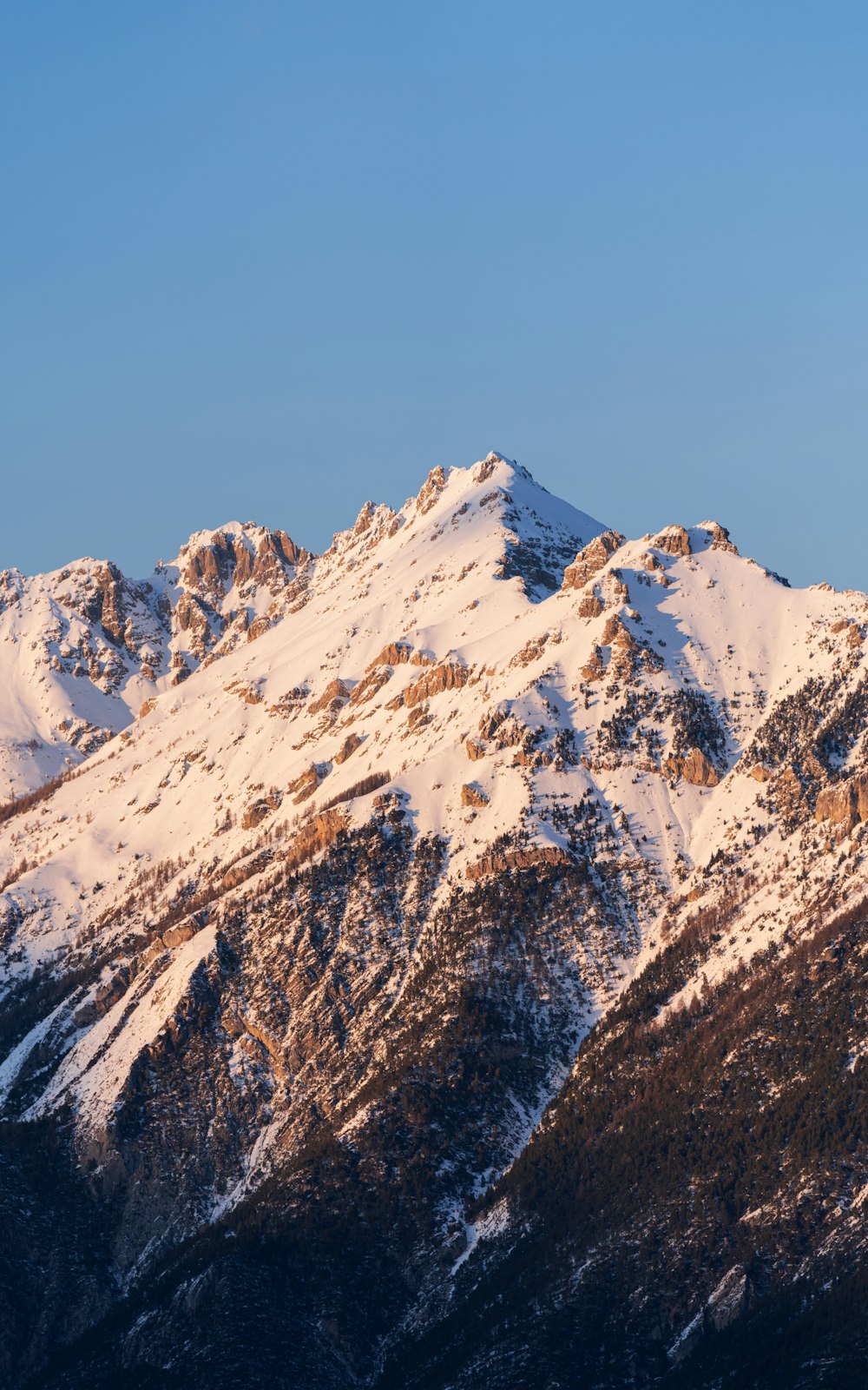 a mountain covered in snow under a blue sky