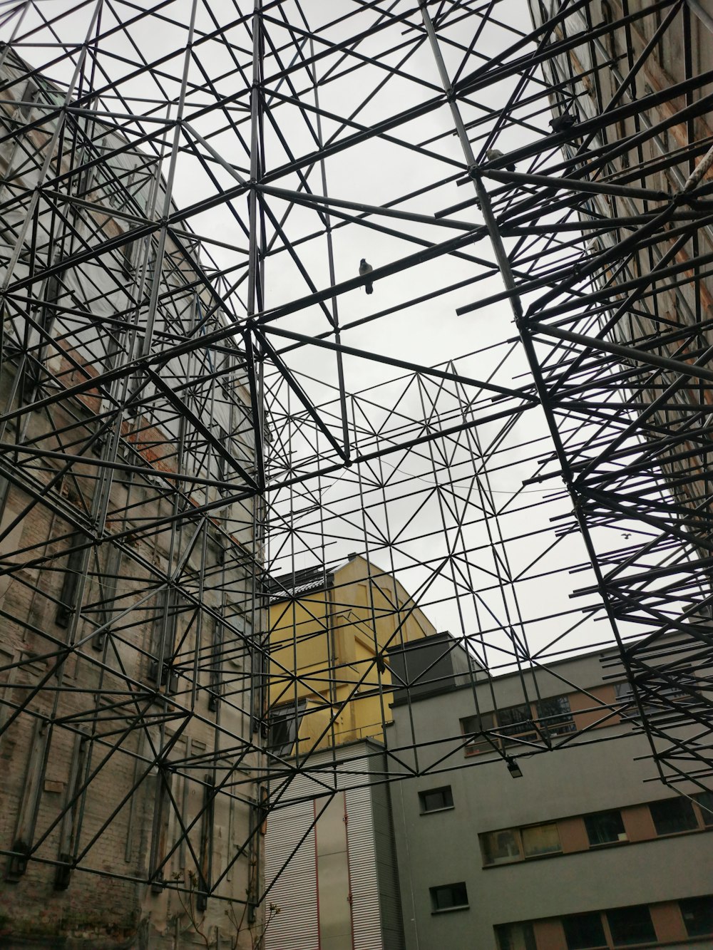 a building with scaffolding on it and a clock tower in the background