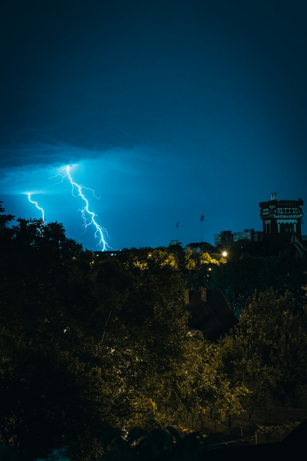 a lightning bolt is seen over a city at night