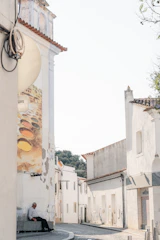 A serene street in Benidorm bathed in soft morning light, highlighting minimalist architecture and quiet urban life.