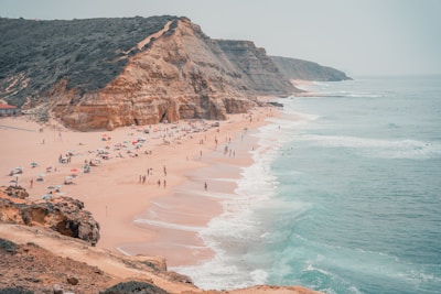 A scenic beach view of Praia da Pipa with tourists enjoying the sun and ocean.