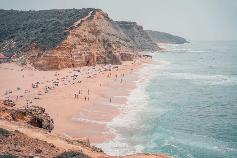 a group of people standing on top of a sandy beach