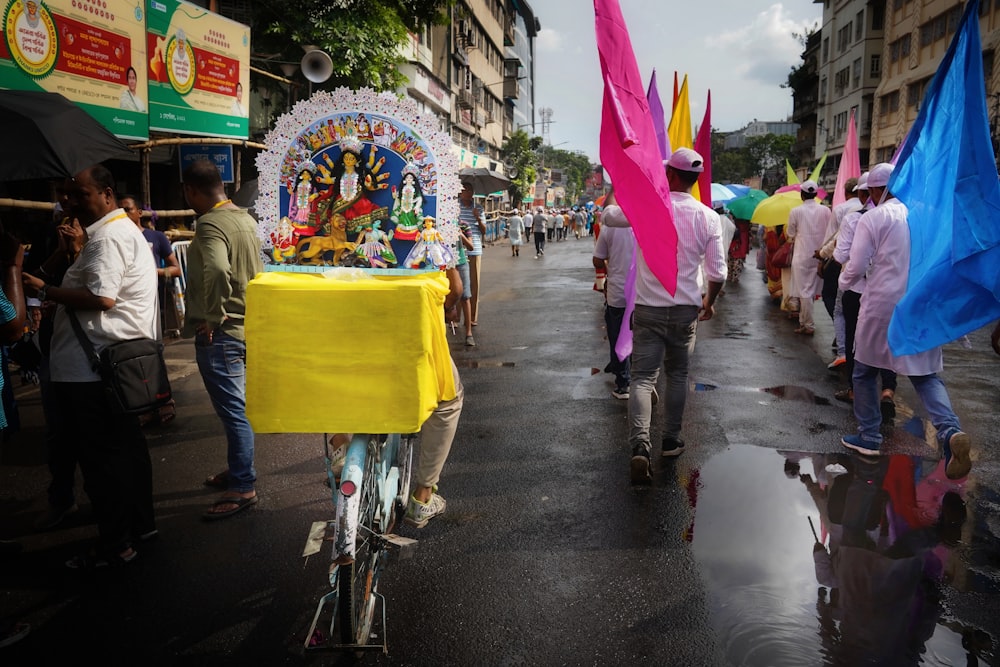 a man riding a bike down a street next to a crowd of people