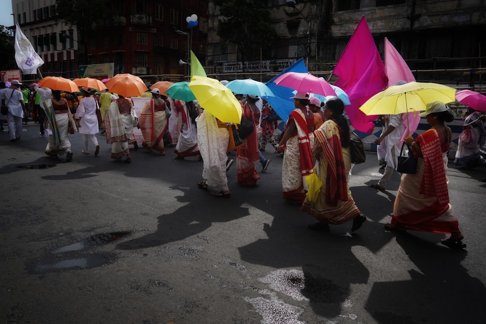 eine gruppe von menschen, die eine straße entlanggehen, regenschirme halten