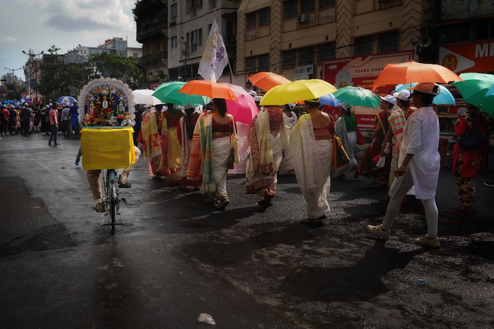 a group of people walking down a street holding umbrellas