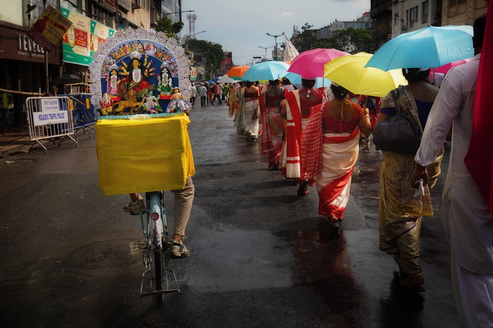 eine gruppe von menschen, die eine straße entlanggehen, regenschirme halten