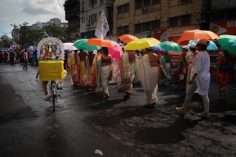 a group of people walking down a street holding umbrellas