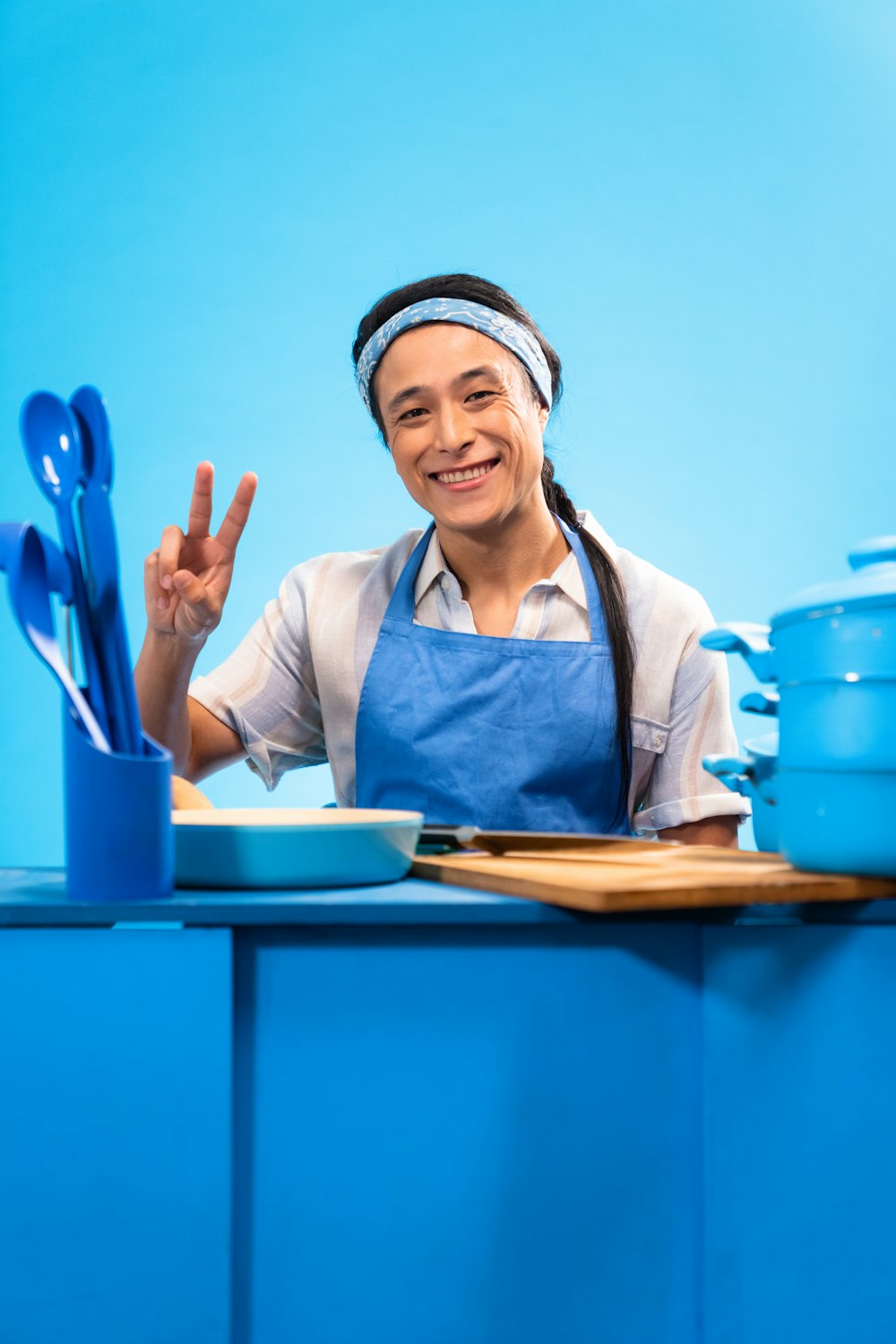 a woman in an apron making a peace sign