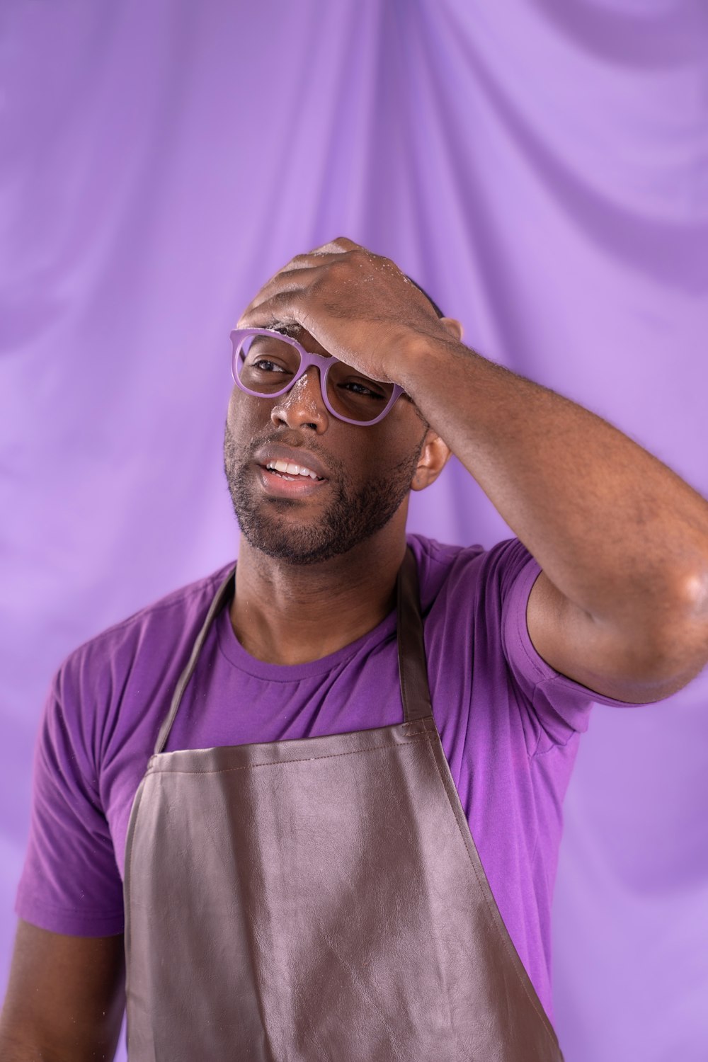 a man in a purple shirt is holding his head