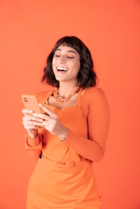 a woman laughing while looking at her cell phone