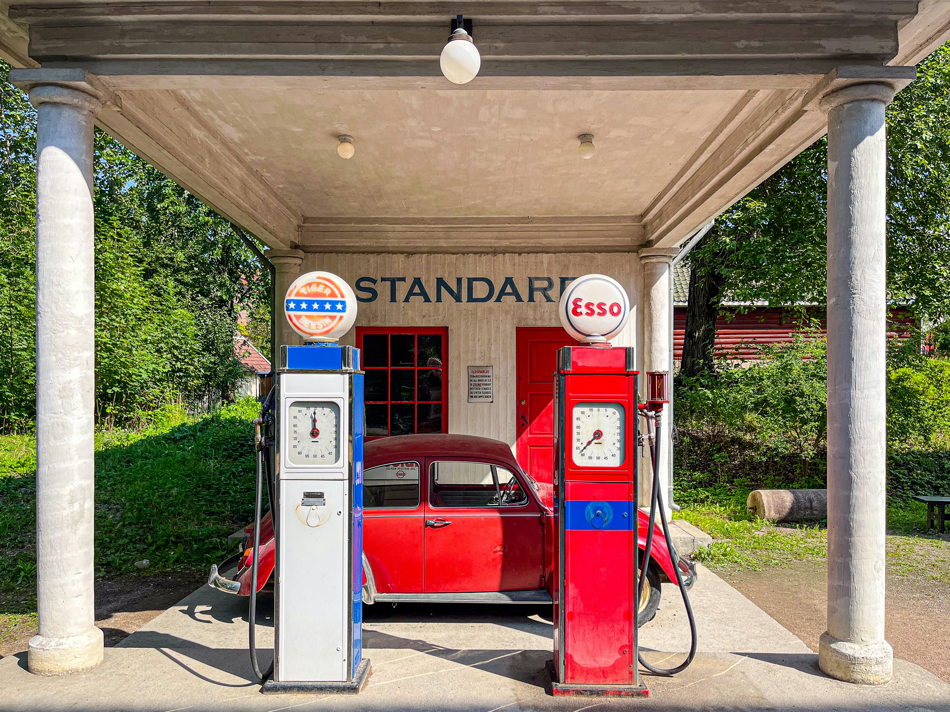 Family on an electric road trip standing by their EV while it charges at a highway station
