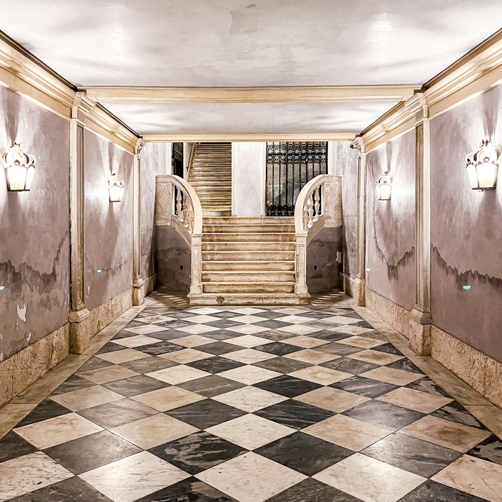 a hallway with a checkered floor and a staircase