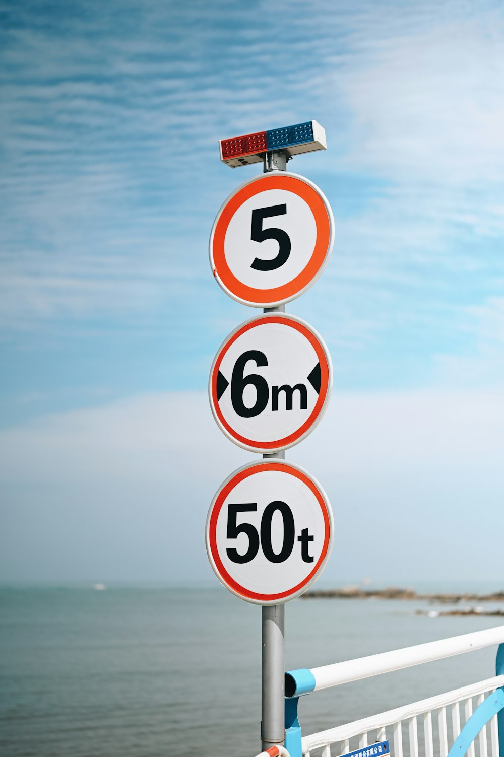 a street sign on the side of a road next to the ocean