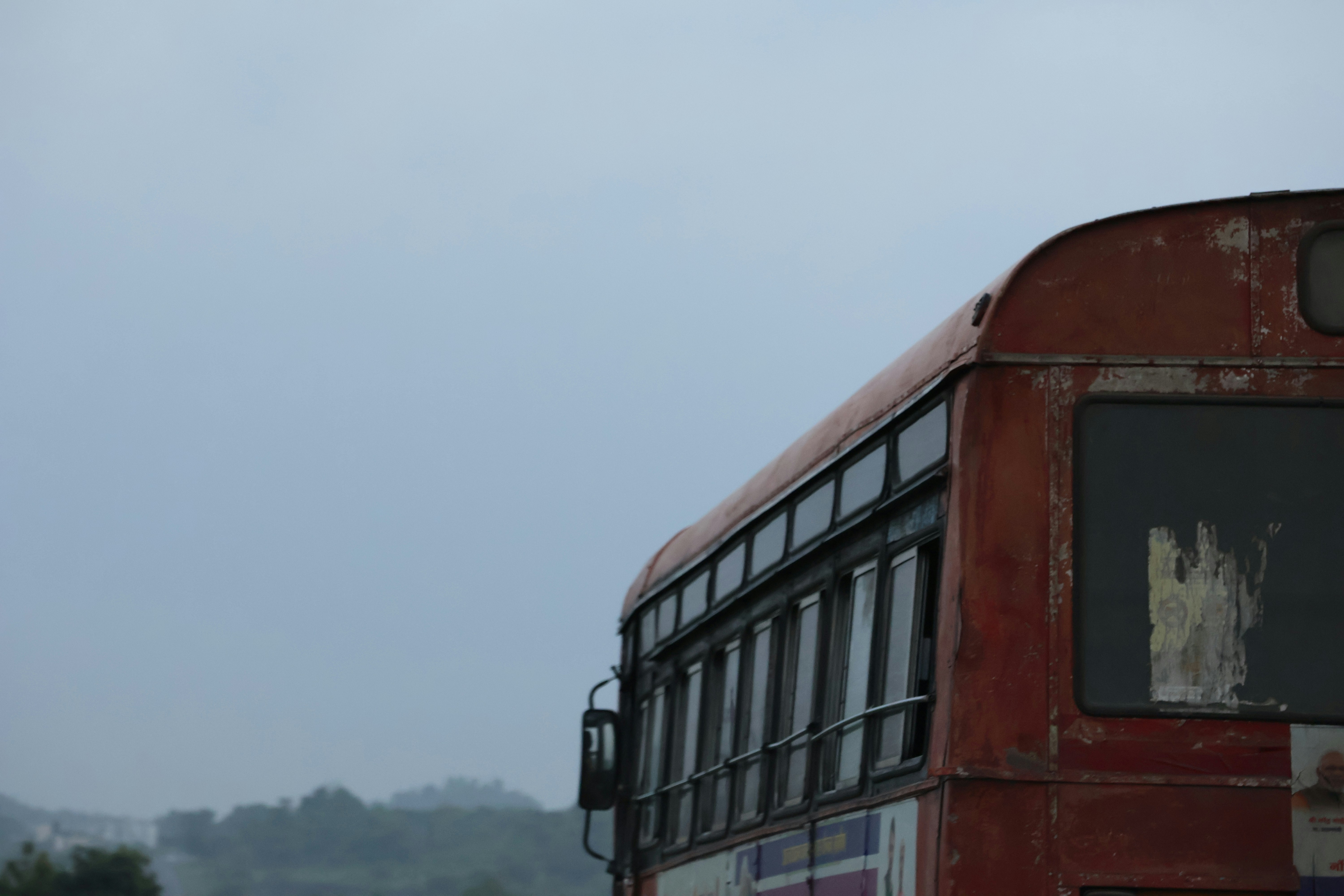 a red double decker bus driving down a street