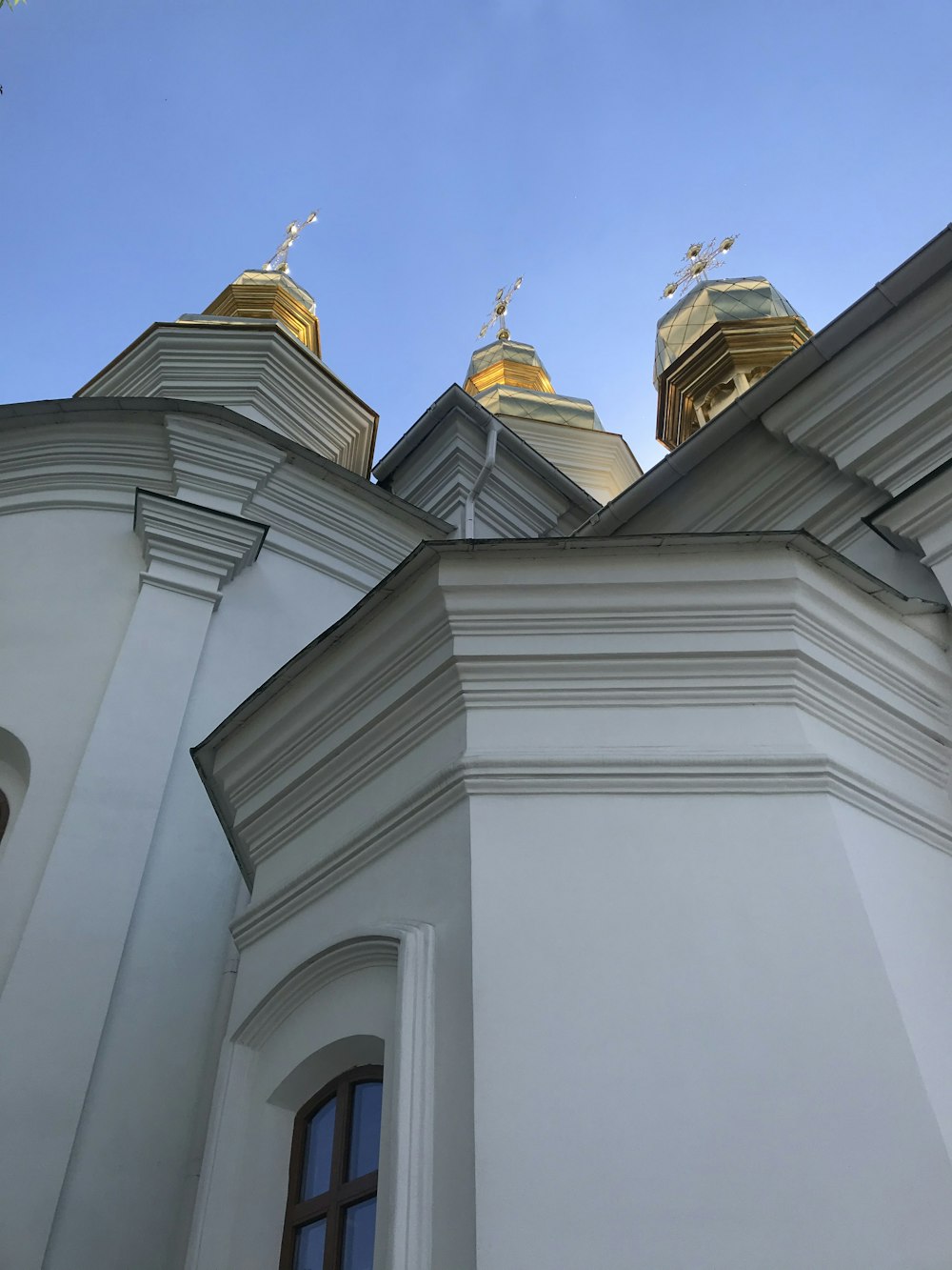 a white building with two gold domes on top