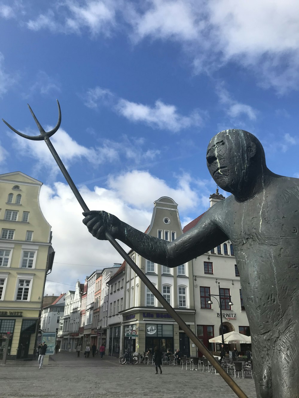 a statue of a man holding a pitchfork