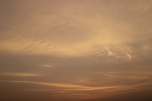 A serene blue sky with soft golden sunlight.